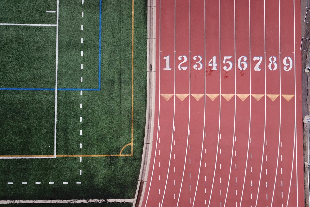 An overhead view of a running track and pitch, with lane numbers painted on the surface